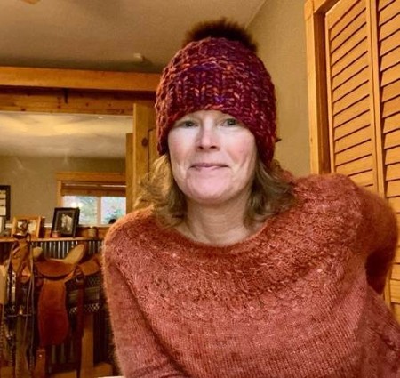 Brandee smiling while showing her new knitted sweater